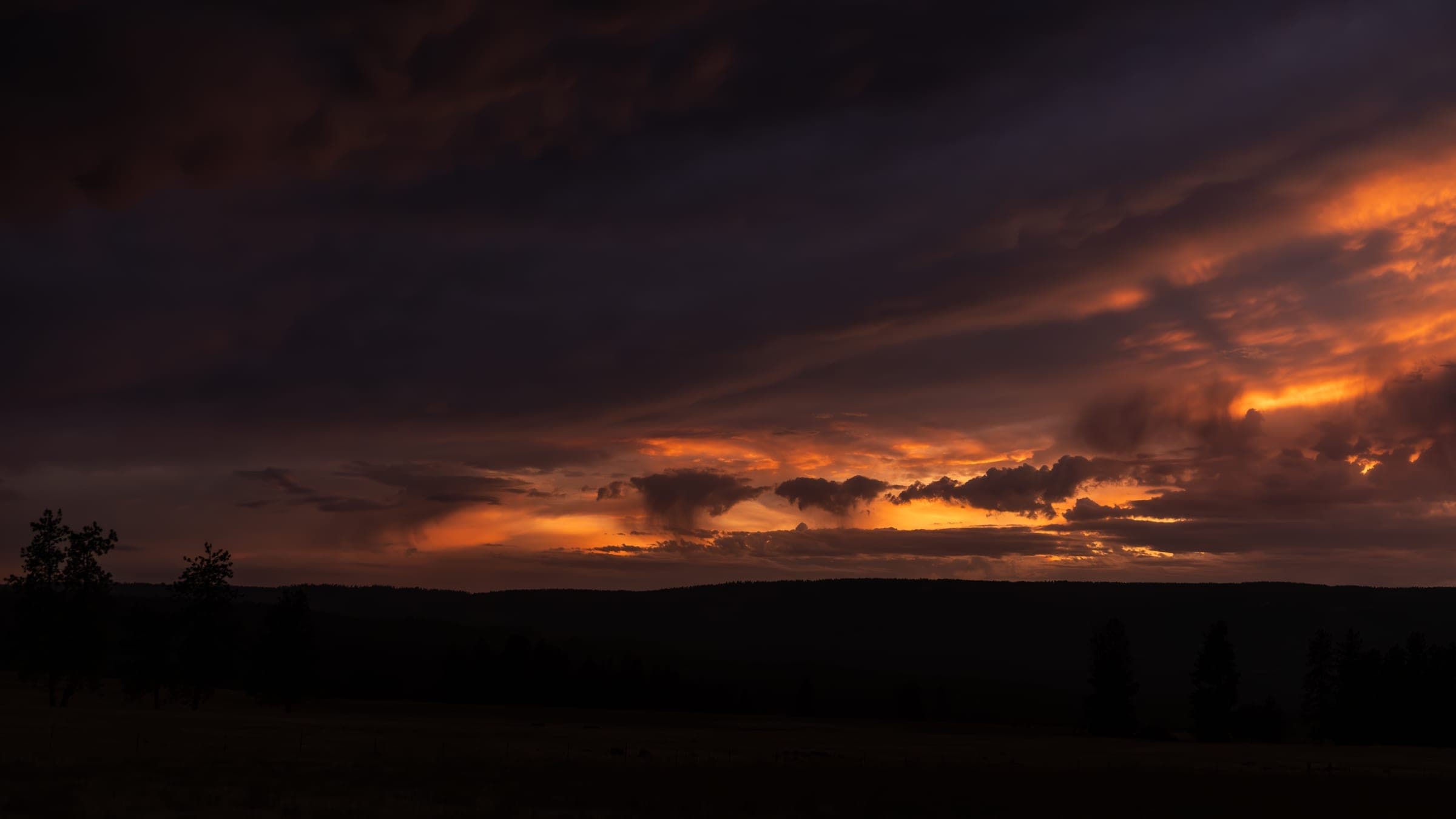 Deep orange sunset behind the valley mountains