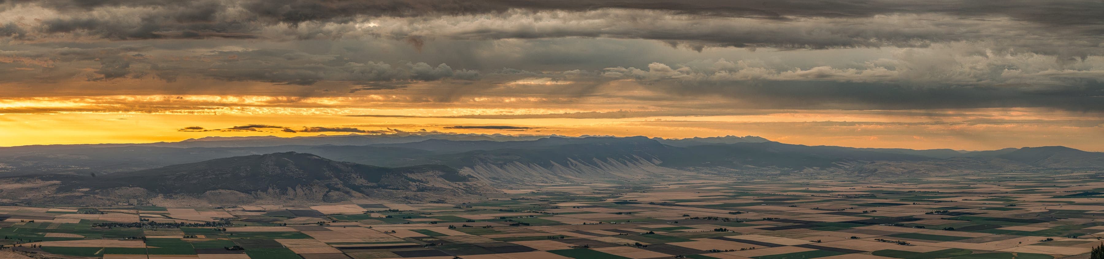 Wide panoramic view of Indian Rock with sun breaking through clouds